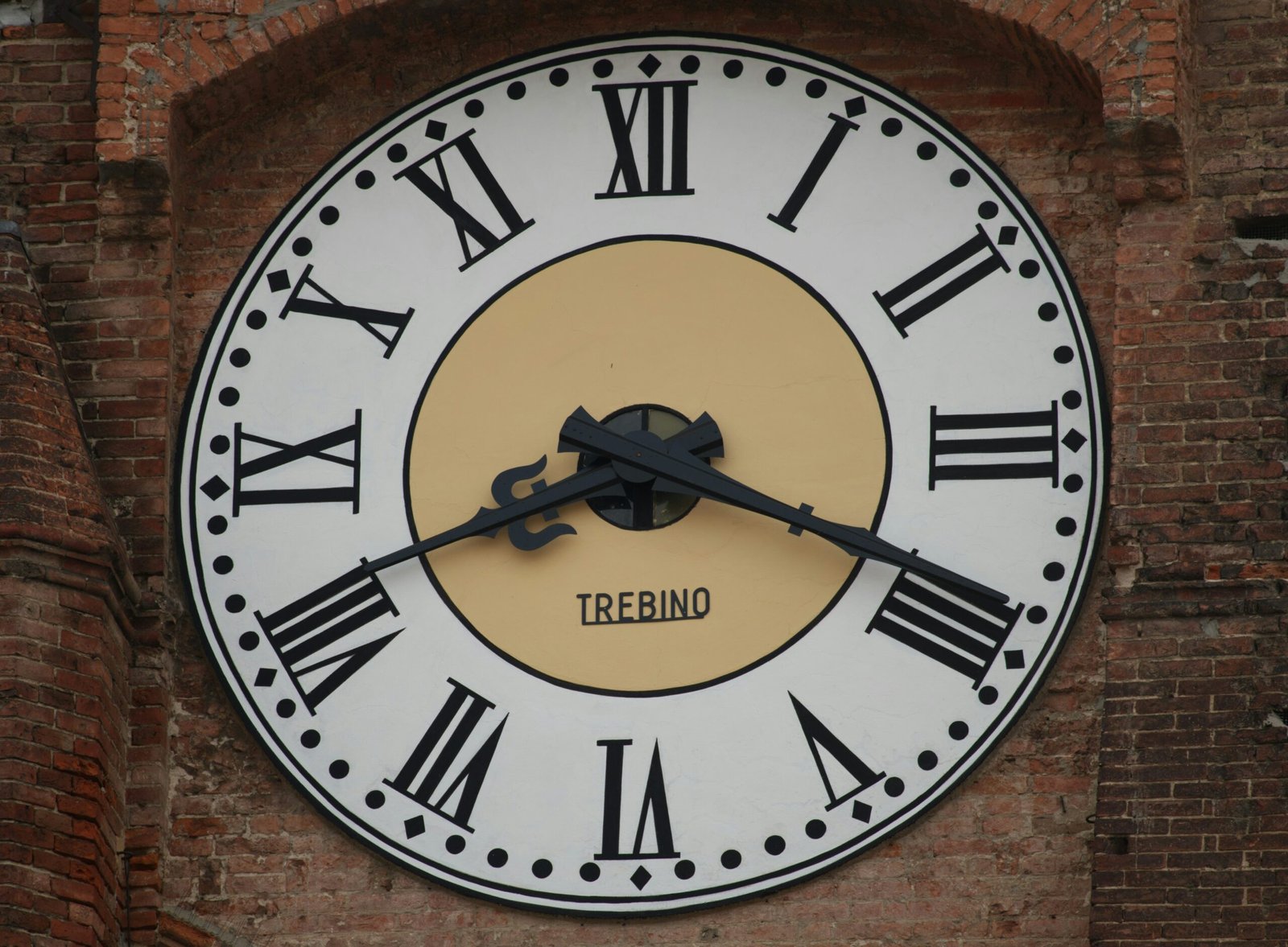 A clock with roman numerals on a brick wall