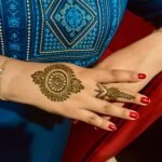 a woman's hand with henna tattoos on it