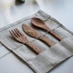 brown wooden fork, spoon, and knife on textile