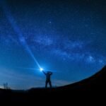 silhouette of man holding flashlight